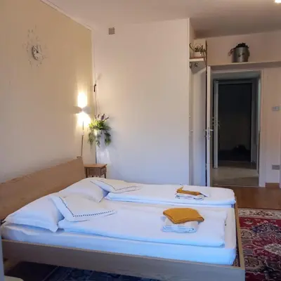 a bedroom with two beds with white sheets at chez Chany in Merano