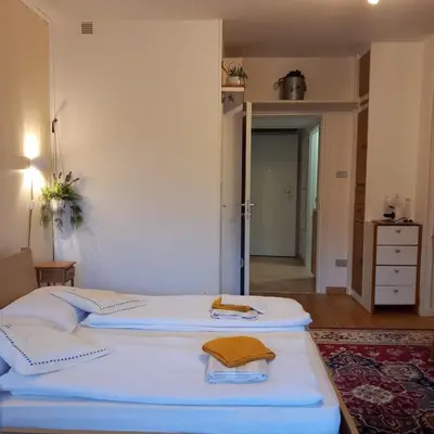 two beds in a room with a door to a bedroom at chez Chany in Merano