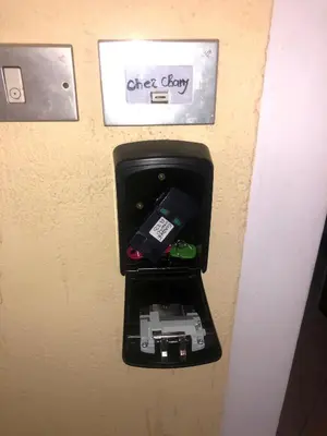 a box with a cell phone and other electronics in it at chez Chany in Merano