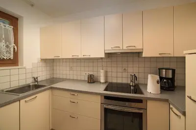 a kitchen with white cabinets and a sink at Moarberg in Brunico
