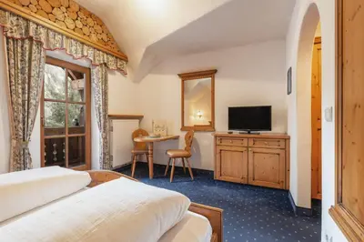 a hotel room with two beds and a television at Leithäusl in San Lorenzo di Sebato