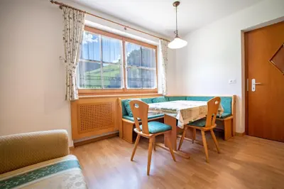 a dining room with a table and chairs and a window at Apartments Berdan in Santa Cristina in Val Gardena