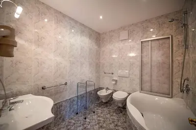a bathroom with a tub and a toilet and a sink at Apartments Berdan in Santa Cristina in Val Gardena