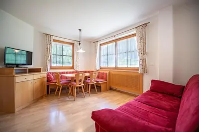 a living room with a red couch and a table at Apartments Berdan in Santa Cristina in Val Gardena