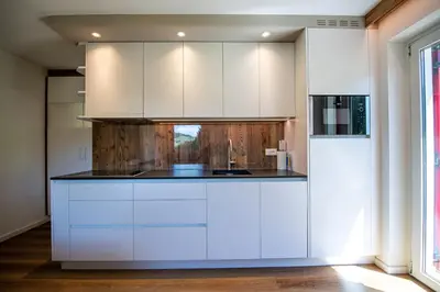 a kitchen with white cabinets and a sink at Apartments Seida in Selva di Val Gardena