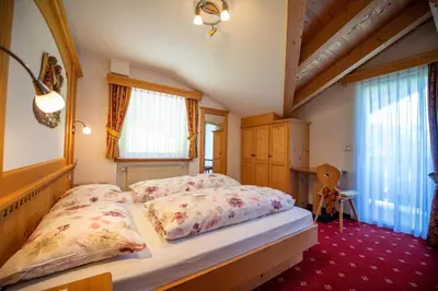 a bedroom with a large bed in a room at Apartments Seida in Selva di Val Gardena