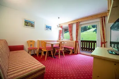 a living room with a table and chairs at Apartments Seida in Selva di Val Gardena