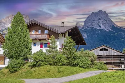 a house in the mountains with a mountain at Apartments Seida in Selva di Val Gardena