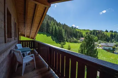 a porch with two chairs and a view of a mountain at Apartments Seida in Selva di Val Gardena