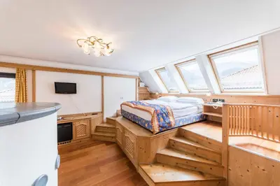 a bedroom in a house with a bed and a sink at Active Hotel Ancora in Predazzo