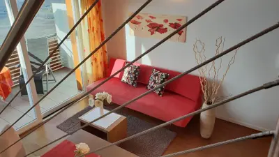 a red couch in a room with a window at Appartements Dornach in Schenna