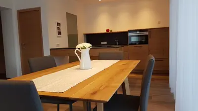 a dining room table with a vase of flowers on it at Appartements Dornach in Schenna