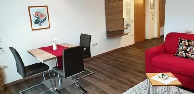 a living room with a red couch and a table at Appartements Dornach in Schenna