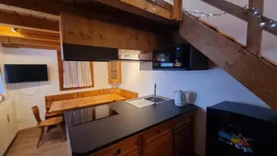 a kitchen with a black counter top in a room at La Casa Degli Artisti - presso Sussy Residence in Falcade