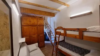 a small room with two bunk beds and a staircase at La Casa Degli Artisti - presso Sussy Residence in Falcade