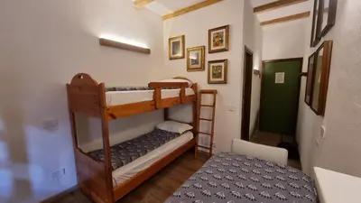 a room with two bunk beds and a hallway at La Casa Degli Artisti - presso Sussy Residence in Falcade