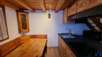 a kitchen with wooden cabinets and a black counter top at La Casa Degli Artisti - presso Sussy Residence in Falcade
