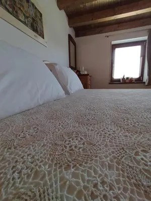 a bedroom with a white bed with a window at I girasoli in Sanzeno