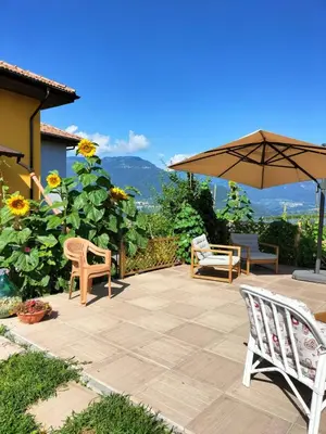 a patio with two chairs and an umbrella at I girasoli in Sanzeno