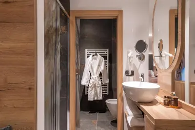 a bathroom with a sink and a toilet and a shower at Hotel Meida in Pozza di Fassa