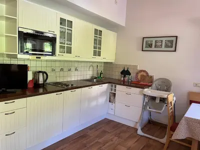 a kitchen with white cabinets and a sink at Haus Helga in Tires