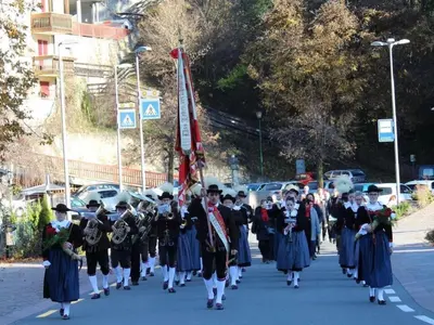 a marching band in a parade down a street at Haus Helga in Tires