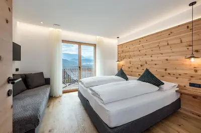 a house with a wooden roof at HAUSERHOF Chalet with Dolomite View in Villandro