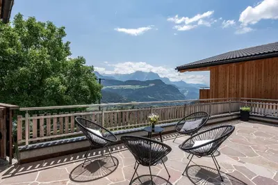 a kitchen and dining room with a table and a chair at HAUSERHOF Chalet with Dolomite View in Villandro