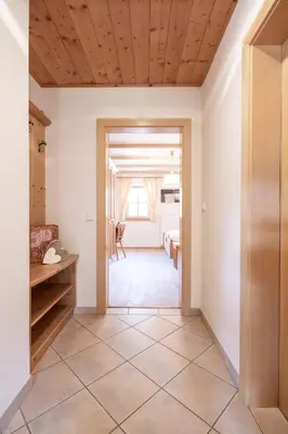 a hallway with a door leading into a room at Loefflerhof in Monguelfo
