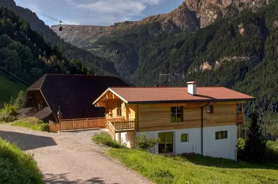 a log cabin in the mountains with a gravel road at Ratzeshof in Castelrotto