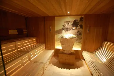 a table with a candle and paper umbrellas on it at Hotel Gstatsch in Alpe di Siusi