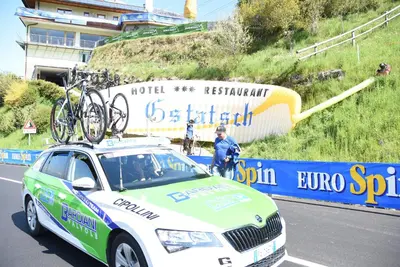 a woman riding a bike down a road with people at Hotel Gstatsch in Alpe di Siusi