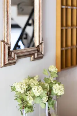 a mirror and flowers in vases on a table at Pension Kleon in Rifiano