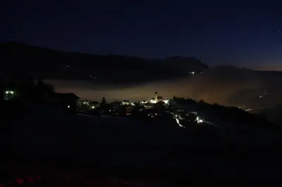 a town on a hill in the fog at night at Gasthaus St. Valentin in Chiusa
