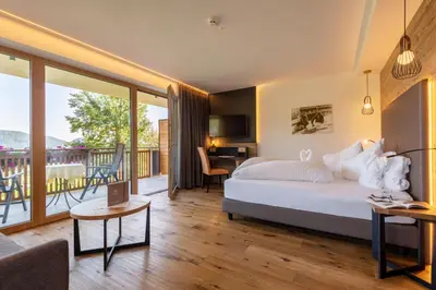 a hotel room with a bed and a balcony at Hotel Sonnenheim in Avelengo