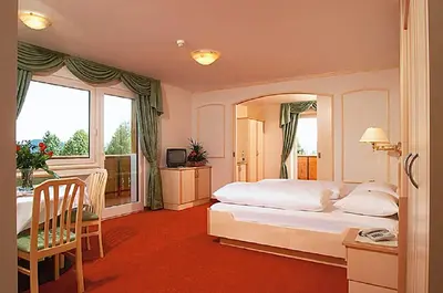 a bedroom with a large white bed and a window at Hotel Sonnenheim in Avelengo