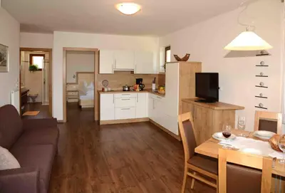 a living room and kitchen with a couch and a table at Plunerhof in Schenna
