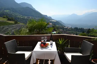 a table with a bowl of fruit and wine glasses at Plunerhof in Schenna