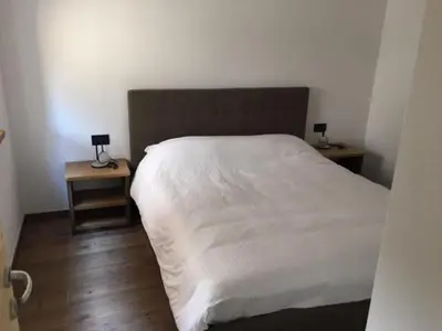 a bedroom with a white bed and two night stands at Casa Fabiolin in Daiano