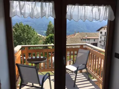 a balcony with two chairs and a table on a deck at Casa Fabiolin in Daiano