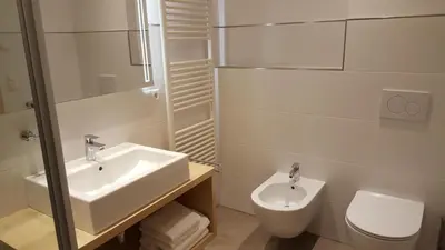 a white bathroom with a sink and a toilet at Residence Klementhof 2 in Fiumes