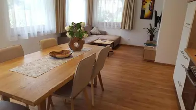 a living room with a wooden table and a couch at Residence Klementhof 2 in Fiumes