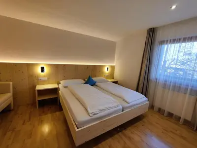a bedroom with a large white bed with a window at Residence Klementhof - A 208 3 in Fiumes