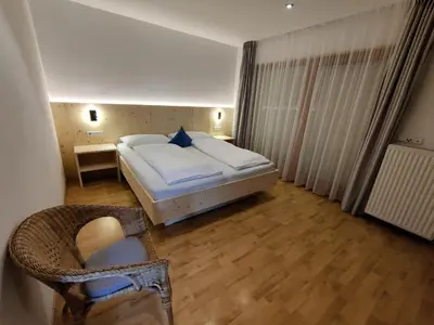 a bedroom with a bed and a chair in it at Residence Klementhof 1 in Fiumes