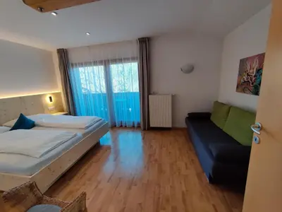 a bedroom with a bed and a couch at Residence Klementhof 1 in Fiumes