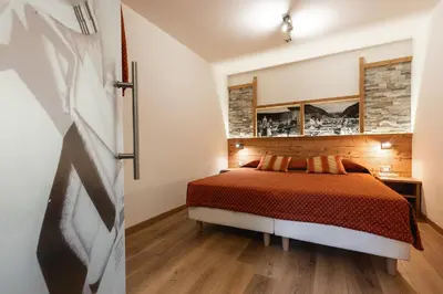 a bedroom with a bed in a room at Hotel Touring in Predazzo