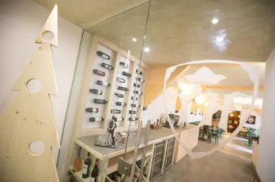 a room with a bunch of shoes on a wall at Hotel Touring in Predazzo