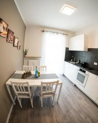 a kitchen and dining room with a table and chairs at Flow Apartments Karl Wolf Park in Merano