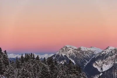 a view of snow covered mountains with a sunset at AMA Stay in San Vigilio Di Marebbe