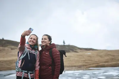 two women standing next to each other holding a camera at AMA Stay in San Vigilio Di Marebbe